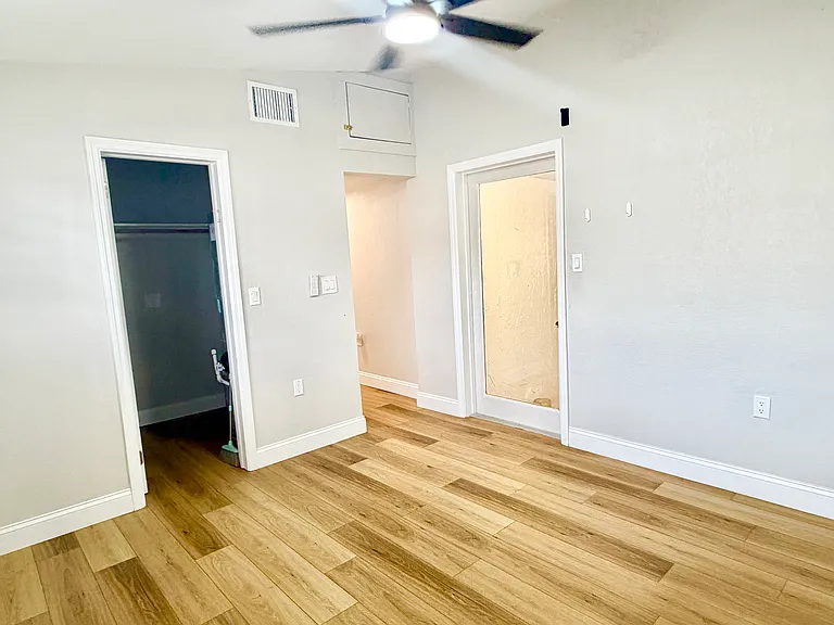 Back sleeping area with walk in closet and door to laundry