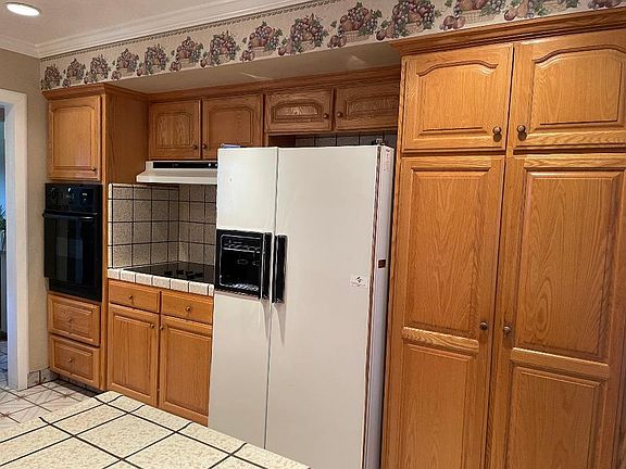 Kitchen with electric stove, wall oven & refrigerator. Lots of extra pantry space
