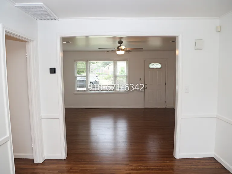 Looking at the living room from the dining room, with the hallway on the left, and kitchen to the right.