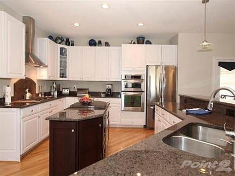 Wolf vented cooktop and Kitchen Aide appliances including a wine refrigerator.  Upgraded hardware, pendulum lighting & center island in this gourmet kitchen.