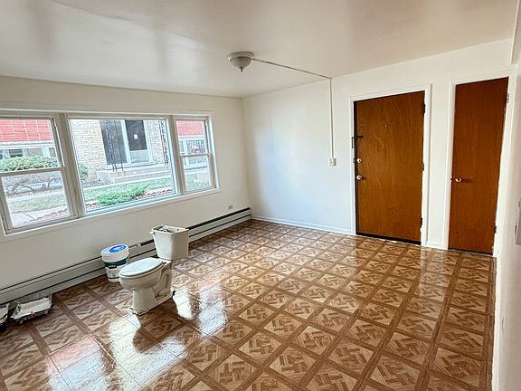 Bright, large living room with natural light (old toilet and paint can have been removed from the unit)