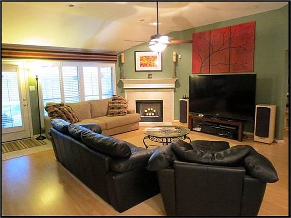 Family room has custom paint, wall of windows and gas fireplace.