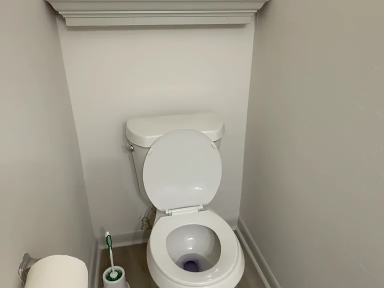 Clean half bathroom with modern flooring and a simple, functional layout - perfect for guest.