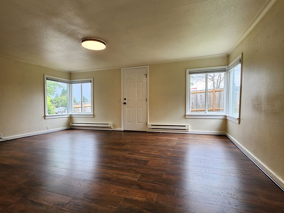Bright living room with corner windows. Newer flooring.