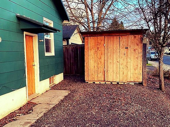 Side of house with parking & storage shed.