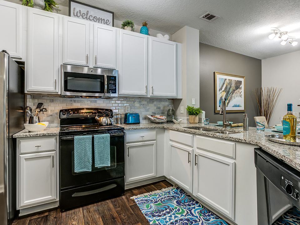 Kitchen featuring large granite counter tops and white cabinets.