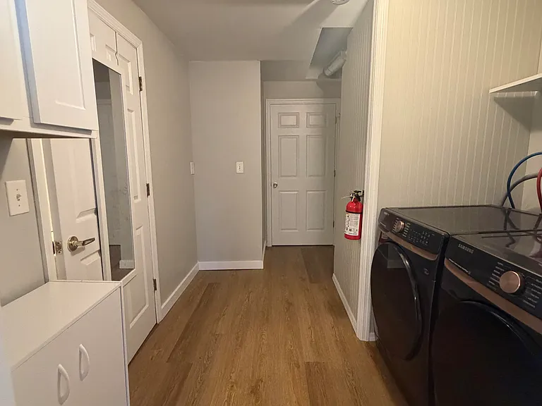 Laundry room with brand new washer and dryer, plenty of cabinets and extra storage space