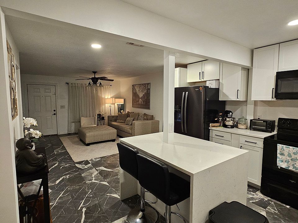The kitchen features built-in Whirlpool appliances, including a refrigerator, dishwasher, stove, microwave, and garbage disposal. A deep farm-style sink adds both function and charm to the space.