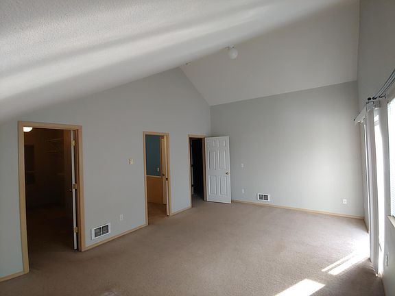 Master bedroom with vaulted ceilings, walk-in closet, and small balcony with slider. Room measures 13ft x 21 feet 6 in.