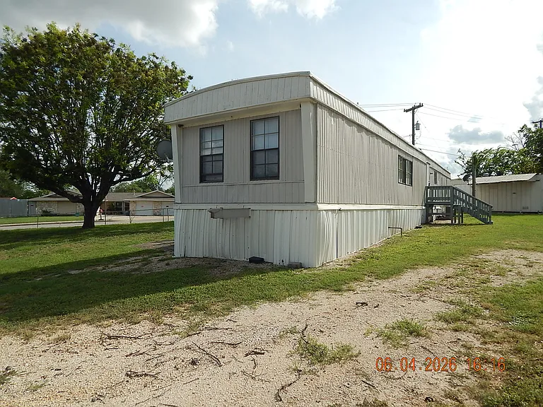 Showing north and front side of home - rear home entrance and shade trees on the left -- totall lot is greater than 0.2 acres