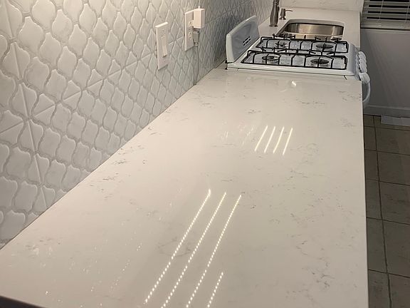 refreshed kitchen with quartz countertop and new range and sink