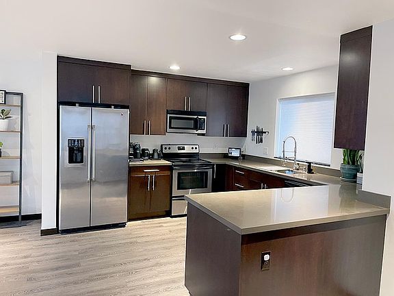 2. Main level open kitchen with u-shaped Caesar stone counter top. Add counter height stools to create a dining area.