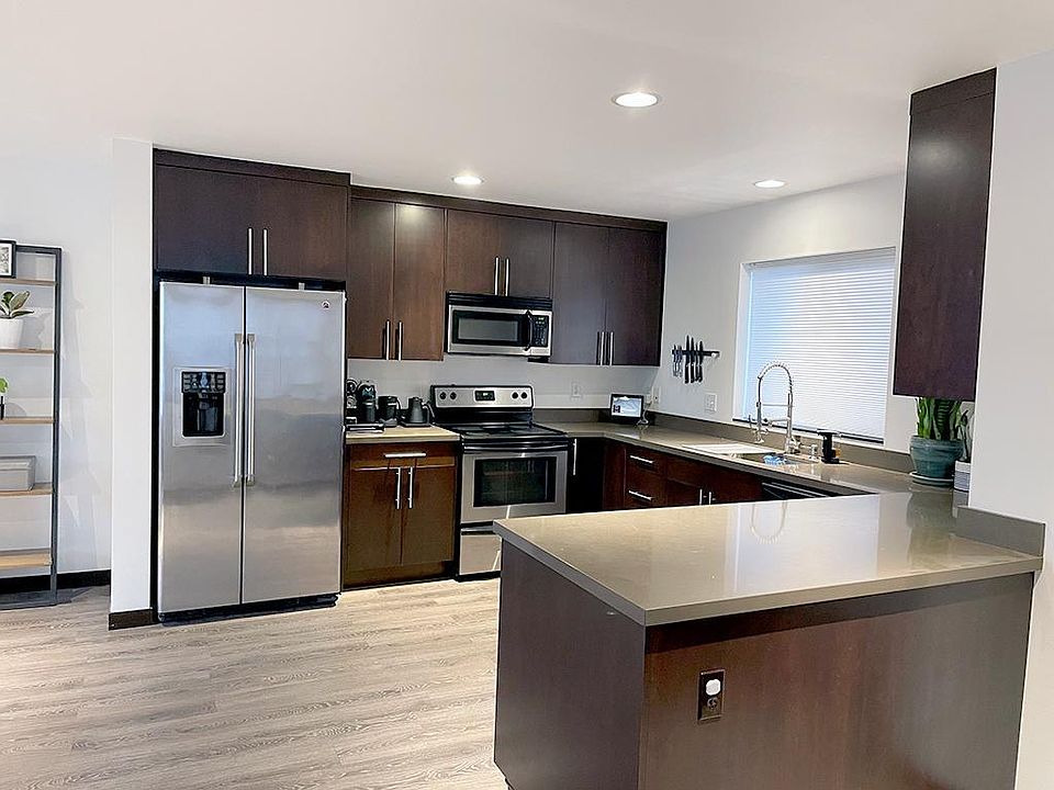 2. Main level open kitchen with u-shaped Caesar stone counter top. Add counter height stools to create a dining area.