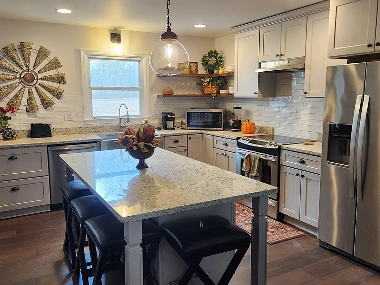 Updated kitchen with large center island, ample cabinetry, and stainless steel appliances for easy everyday cooking.