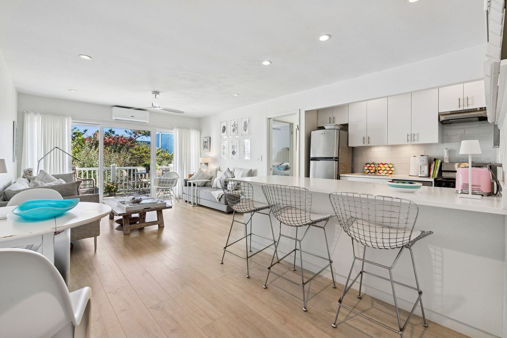  Open plan with ample living, dual sofas, breakfast bar, and sliders to the private deck.
