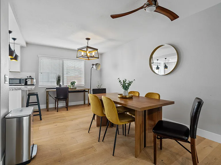 A gleaming dining table stretches the length of the room, surrounded by high-backed chairs.