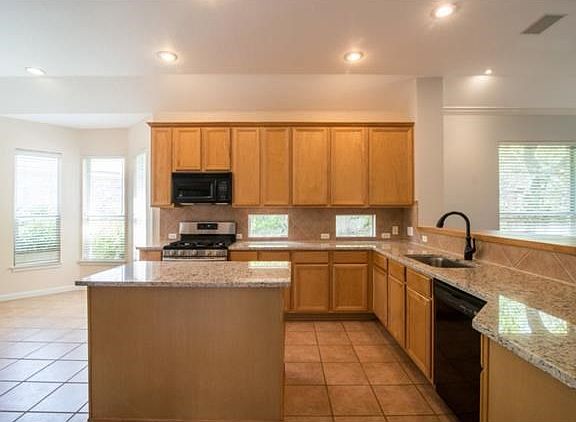Open Kitchen Complete with Island, SS Appliances, and Granite Counter Tops