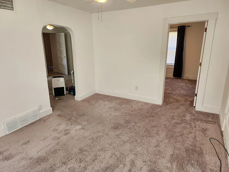 Living room. Doorway on right leads to master bedroom. Left arched doorway leads back to dining room.