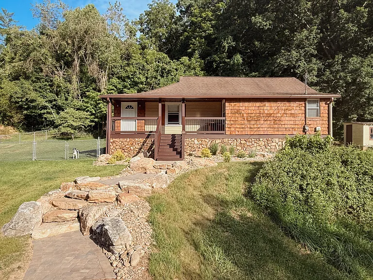 Stone-paver walkway and boulder steps lead to the front porch