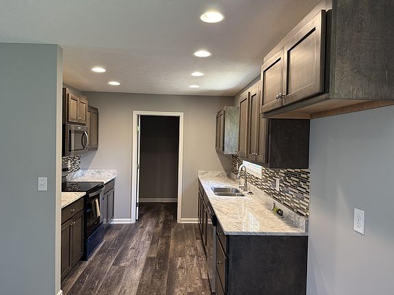 Galley kitchen with all new stainless appliances, granite countertops. Access to full laundry room