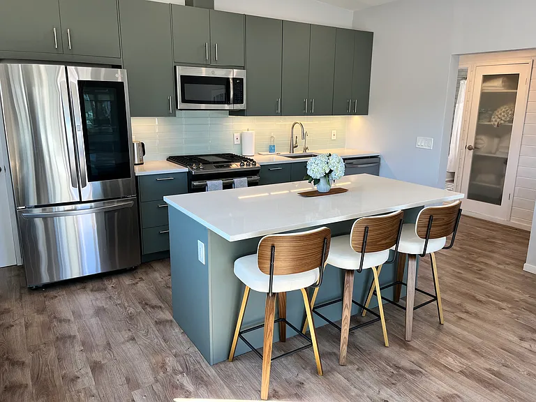 Kitchen.
4-burner range with center griddle.
Reverse-osmosis water dispenser.
French-door refrigerator with beverage window.
Dishwasher.
Built-in microwave.