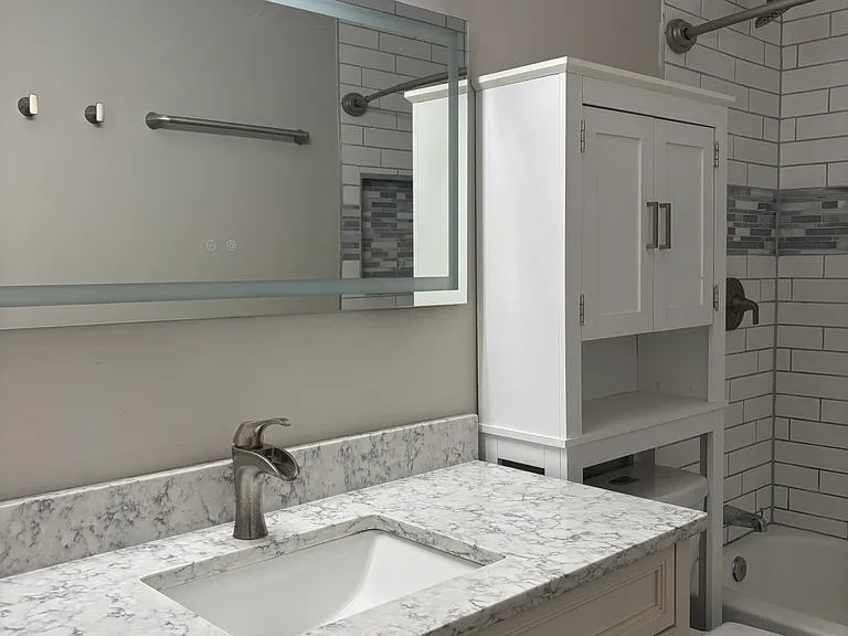 Completely renovated bathroom features large vanity. Built-in over-toilet storage!