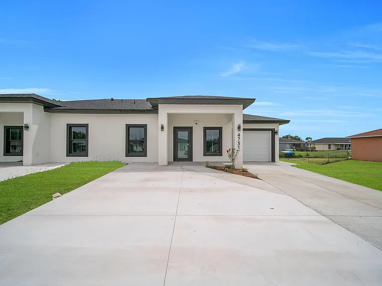 Single-story home with a covered entry, wide driveway, and attached garage, plus low-maintenance front landscaping.