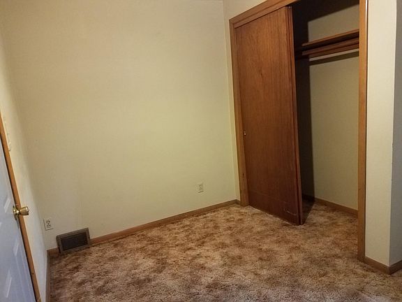 bedroom with open closet door and closed back entry door