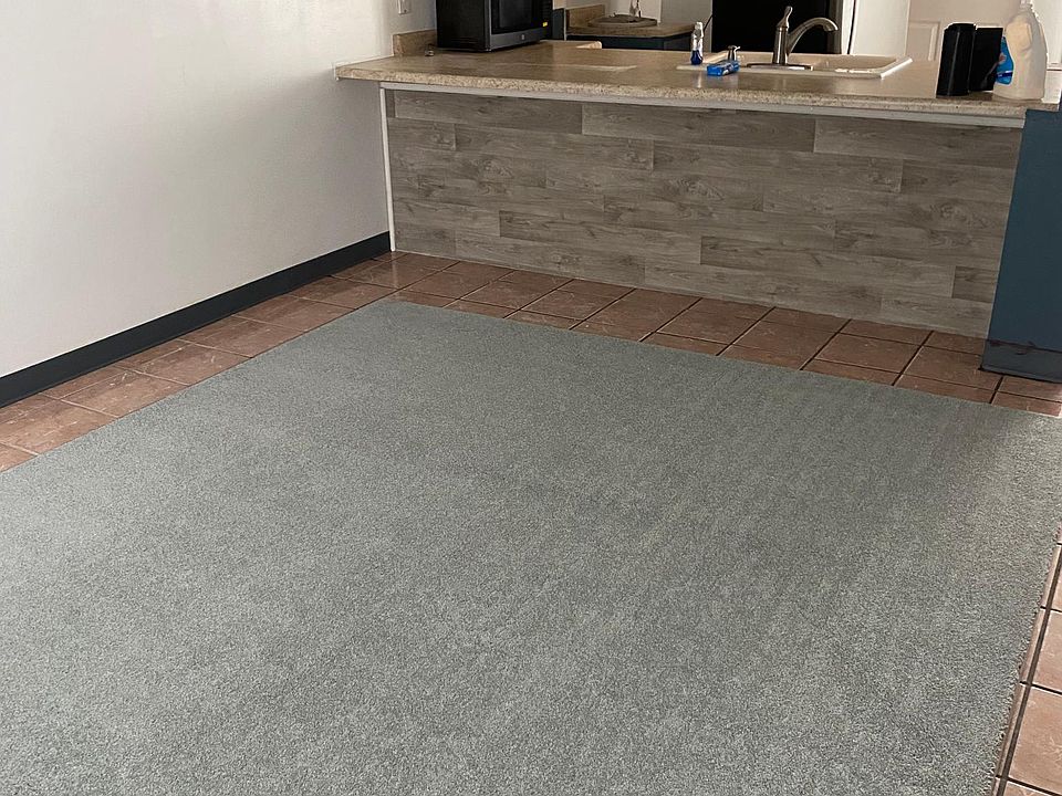 Livingroom and kitchen with breakfast bar. Area rug stays