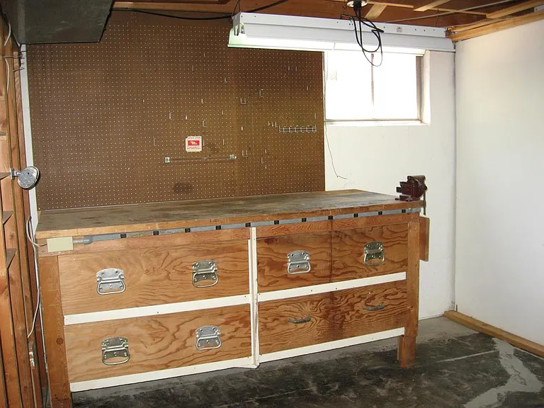Utility room with a large workbench, lots of storage space and washer/dryer hook-ups