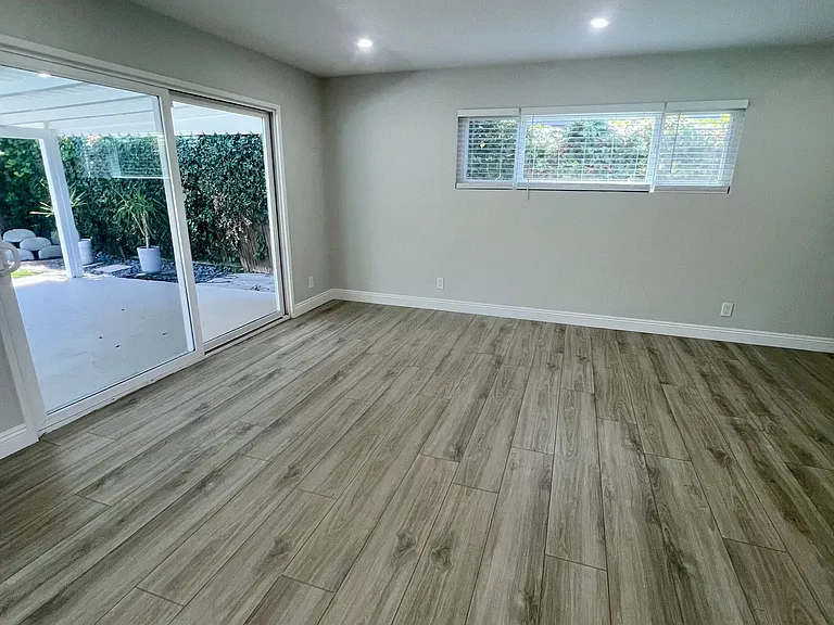 Den area with sliding glass doors to patio and yard