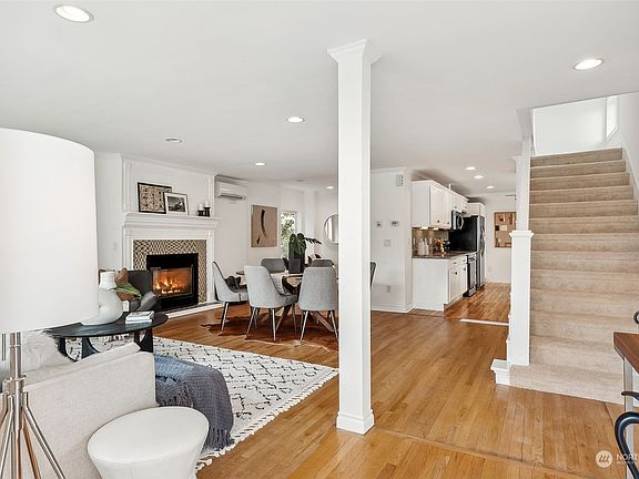 Main level boasts an electric fireplace, open floorplan, and convenient access to the primary bedroom suite upstairs.>