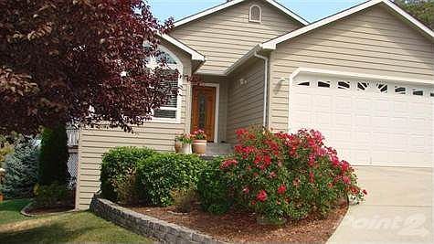 Front of home welcomes you with colorful shrubs and a clean and tidy appearance. The GPID canal runs