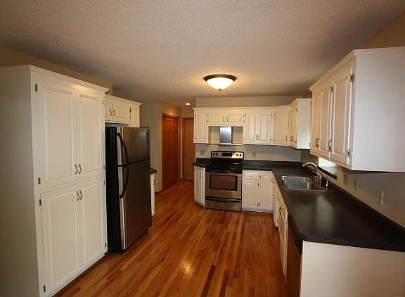 Nice Kitchen with white woodwork, stainless steel appliances and wood floor.