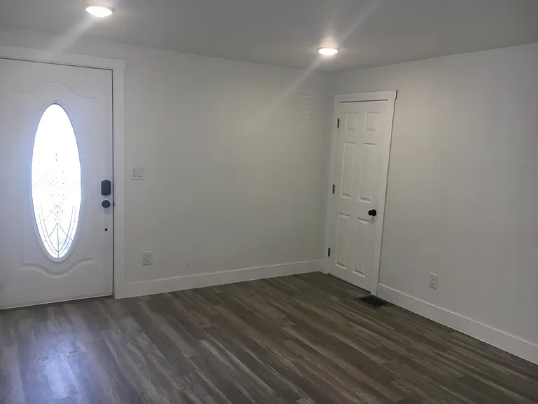Living room with front door and closet door.