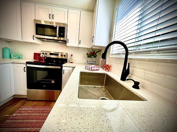 brand new kitchen with fresh appliances, cabinets and counters