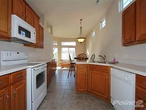 Large, tiled kitchen with transom window, generous Maple glazed cabinets and walk-in pantry.  All appliances including smooth top oven/range, built-in microwave, side by side refrigerator stays.