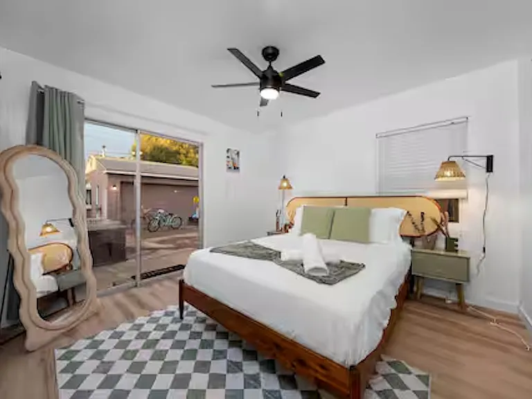 Modern kitchen with white cabinetry, stainless steel appliances, and stone benchtops, featuring a coffee machine, blender, stove cooktop, and plenty of natural light.