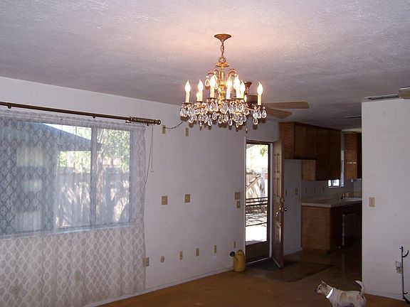 cyrstal chandelier in large carpeted living room includes charming wood stove 