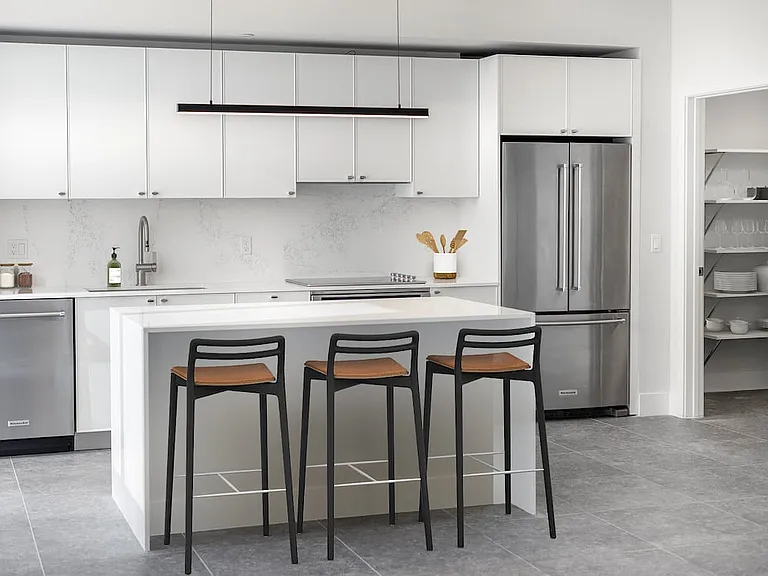 Signature Collection Townhome kitchen with white cabinetry, white marbled quartz countertop and backsplash, wine fridge, and upgraded stainless steel appliances