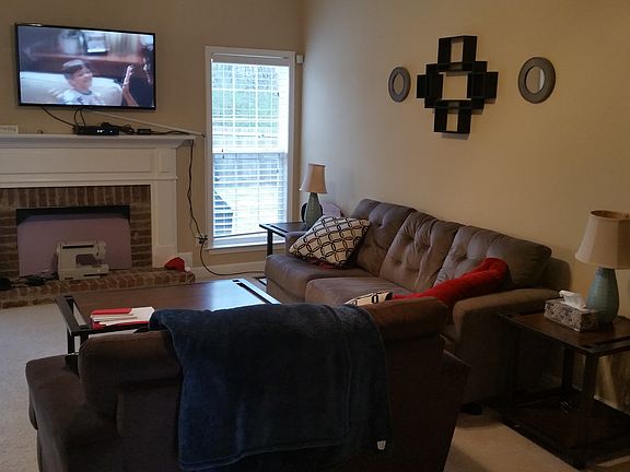 Living room with fireplace and door to fenced backyard and patio.