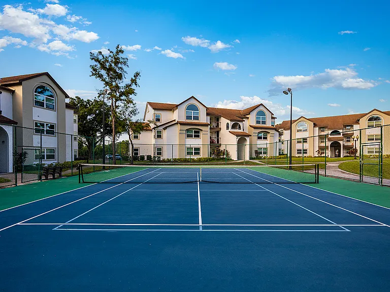 Full-sized, lakeside tennis court with evening lighting