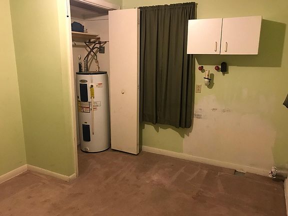 Bedroom/laundry room. Laundry hookups are in here, but the room was a bedroom before. Water heater does take up half the closet.
