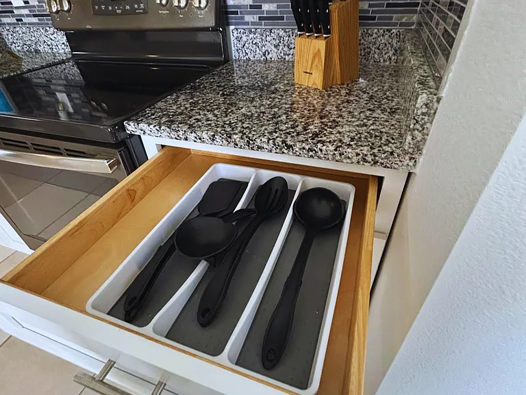 Kitchen stocked with knives, serving utensils, and cooking essentials.