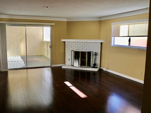 Corner fireplace in large living room. Connected to large outdoor patio.