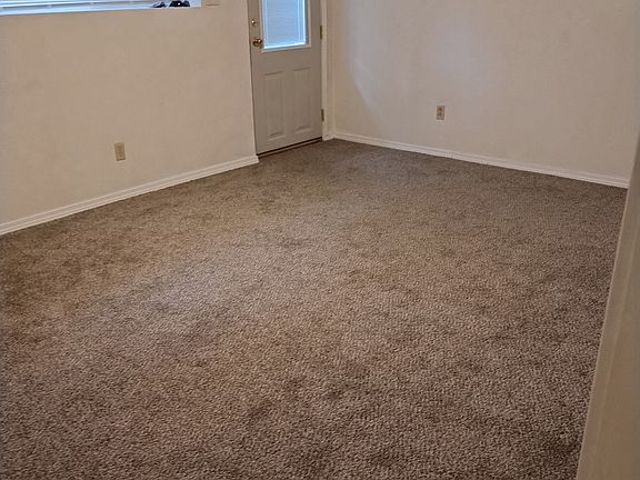 Living room and outside door with privacy blind.