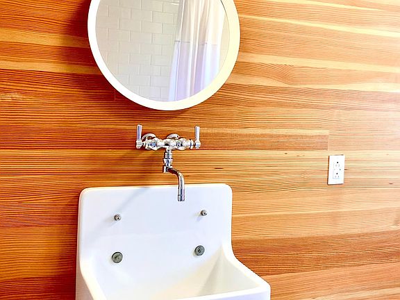 Downstairs bathroom farm sink on Fir wall with marble floor.