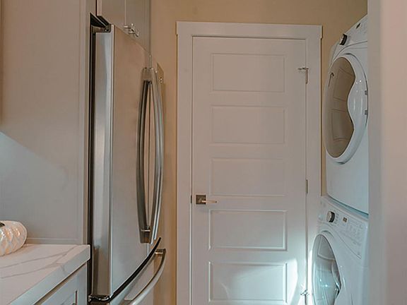 The energy efficient washer/dryer face the refrigerator.