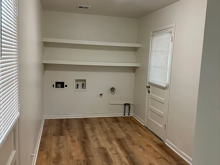 Laundry room with washer and dryer hookups, plus doors leading to the garage and backyard.