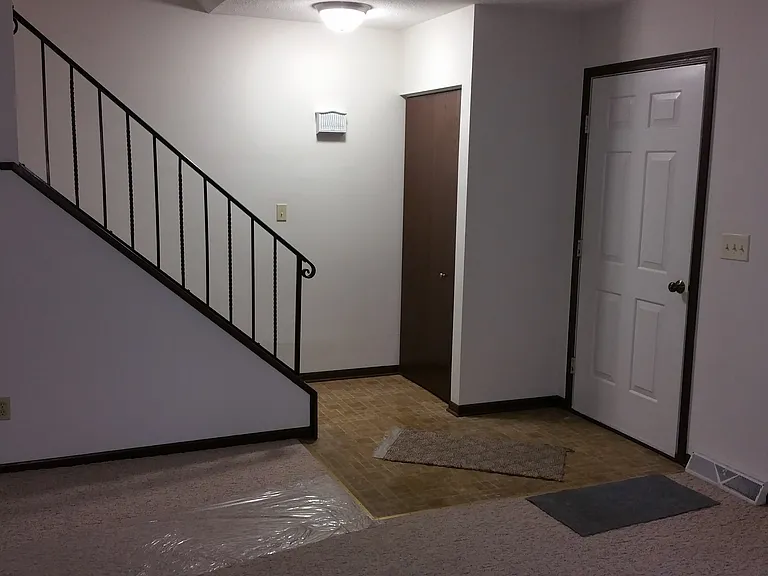 Front door, coat closet, steps to upstairs